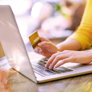 Image of a person on a laptop with a payment card